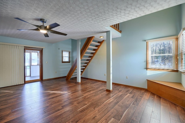 unfurnished living room featuring a textured ceiling, dark hardwood / wood-style floors, and ceiling fan