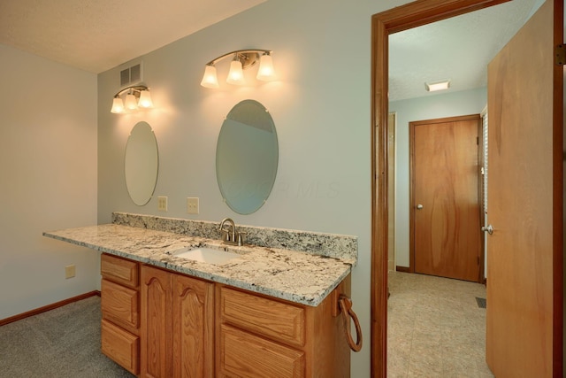 bathroom with a textured ceiling and vanity