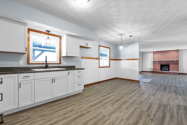 kitchen with sink, hanging light fixtures, and white cabinets