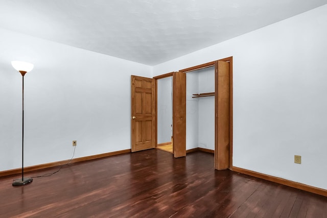 unfurnished bedroom with dark wood-type flooring