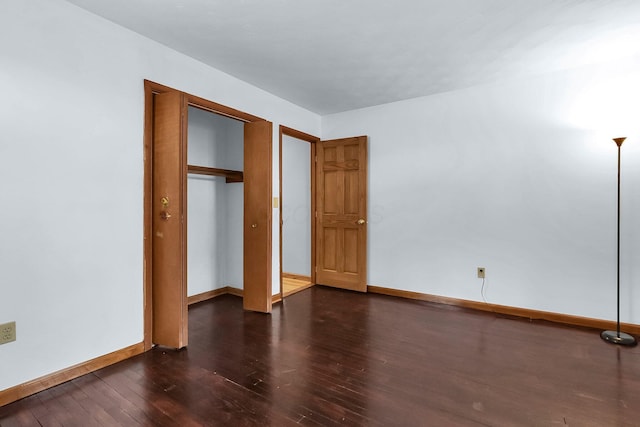 unfurnished bedroom featuring dark hardwood / wood-style flooring and a closet