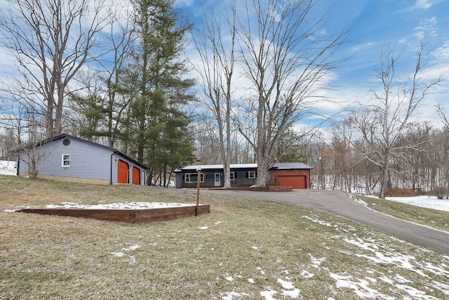 yard covered in snow with a garage and an outbuilding