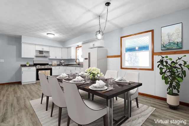 dining area with sink and light wood-type flooring