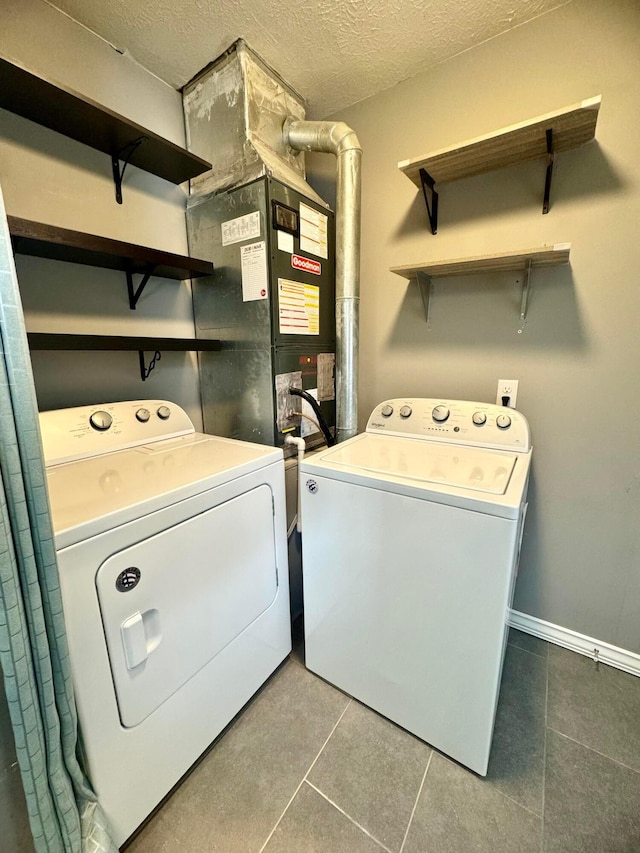 laundry room featuring heating unit, a textured ceiling, separate washer and dryer, laundry area, and tile patterned floors