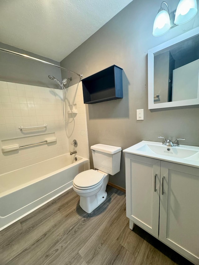 full bath with a textured ceiling, vanity, wood finished floors, and toilet