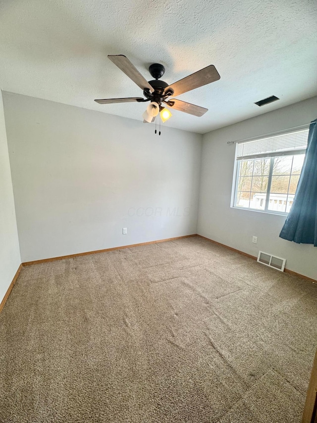 unfurnished room featuring a textured ceiling, ceiling fan, and carpet