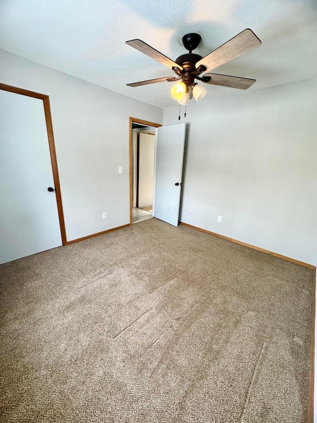 spare room featuring carpet, a textured ceiling, and baseboards