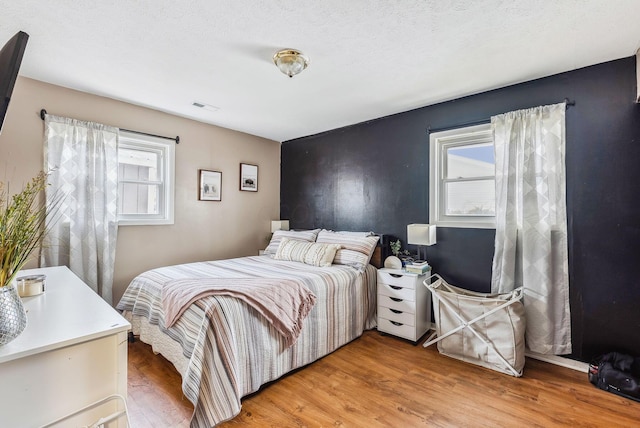 bedroom featuring hardwood / wood-style flooring and a textured ceiling