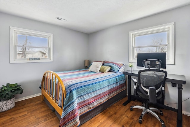 bedroom featuring multiple windows and dark wood-type flooring