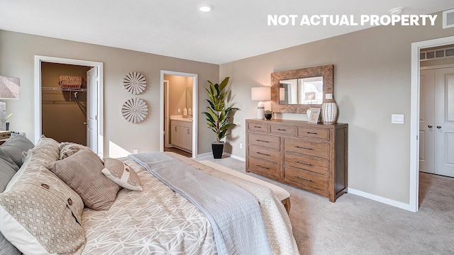 carpeted bedroom with ensuite bathroom, a walk in closet, and a closet