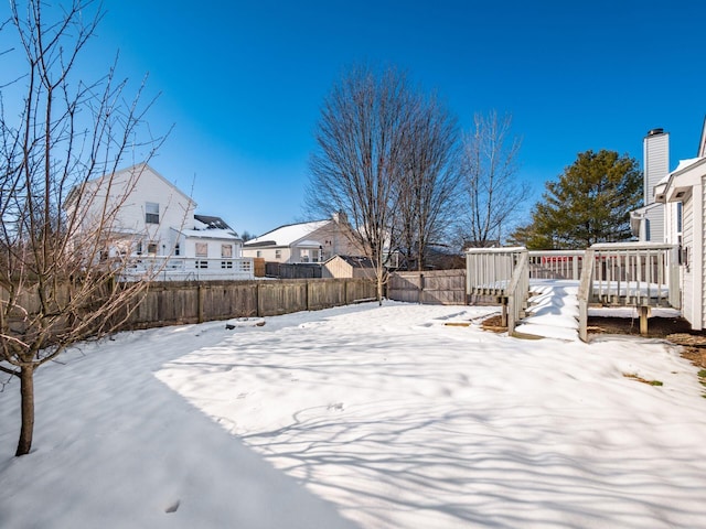 snowy yard with a deck