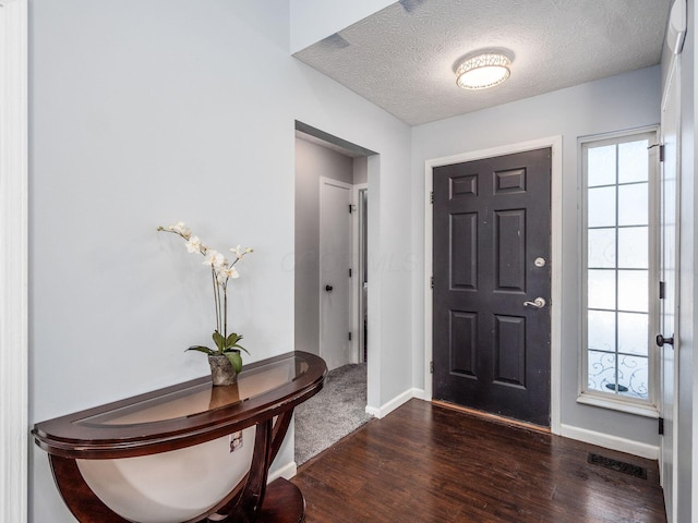 entrance foyer with dark hardwood / wood-style flooring and a textured ceiling