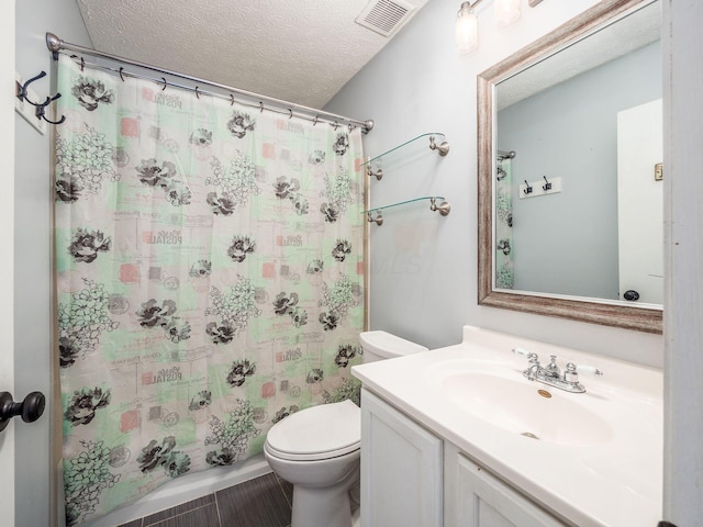 bathroom featuring a textured ceiling, tile patterned flooring, vanity, toilet, and a shower with shower curtain