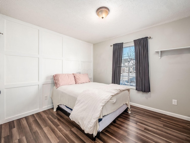 bedroom with dark hardwood / wood-style flooring and a textured ceiling