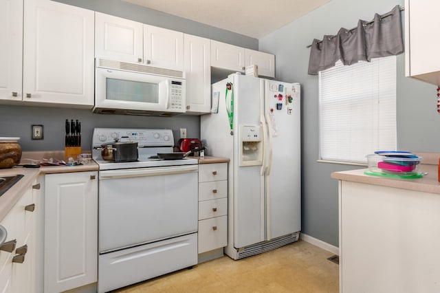 kitchen with white cabinetry and white appliances