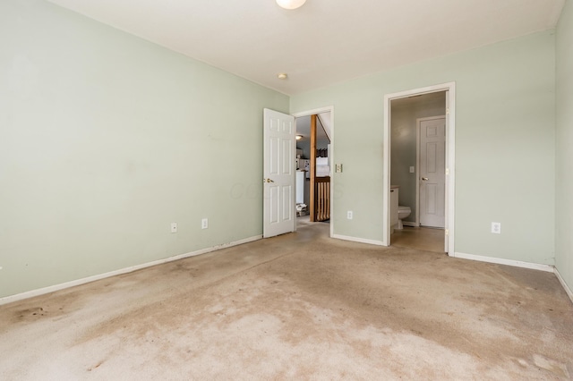 unfurnished bedroom featuring ensuite bathroom and carpet floors