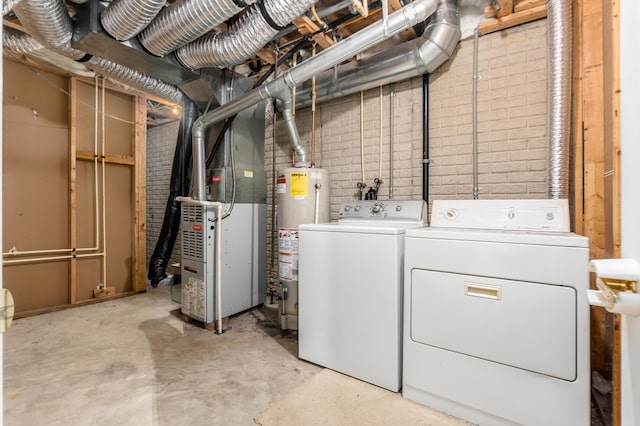 washroom featuring washing machine and dryer, heating unit, and gas water heater