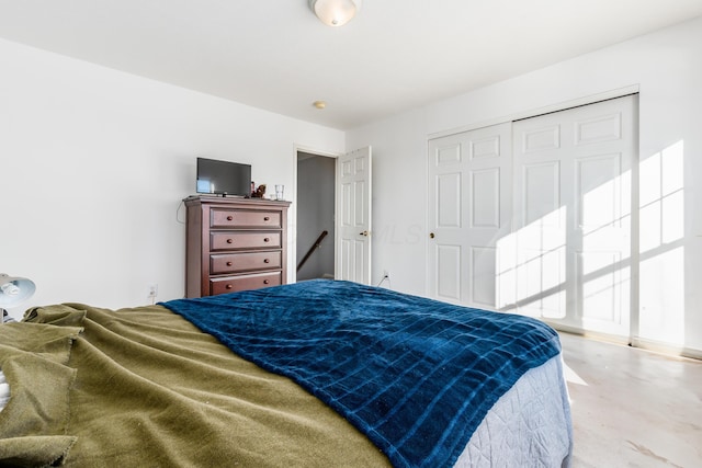 bedroom with a closet and concrete floors