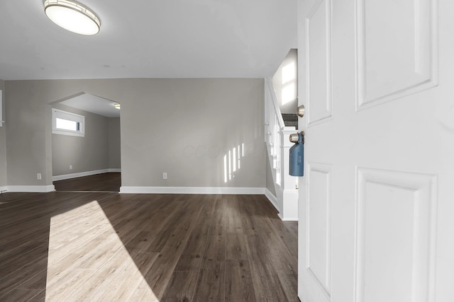 unfurnished living room with dark hardwood / wood-style flooring