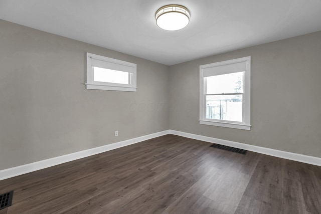 unfurnished room featuring dark hardwood / wood-style floors and a wealth of natural light