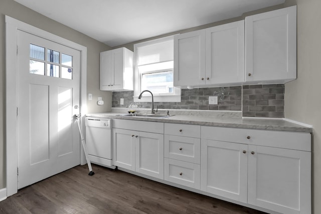 kitchen with white cabinetry, dark hardwood / wood-style flooring, tasteful backsplash, sink, and white dishwasher