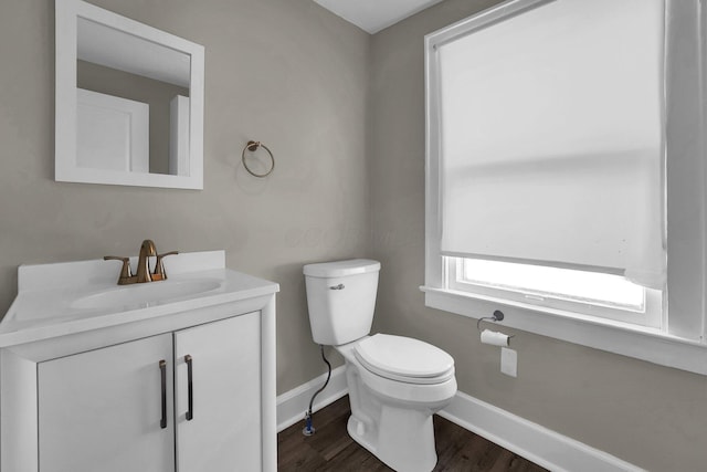 bathroom featuring wood-type flooring, toilet, and vanity