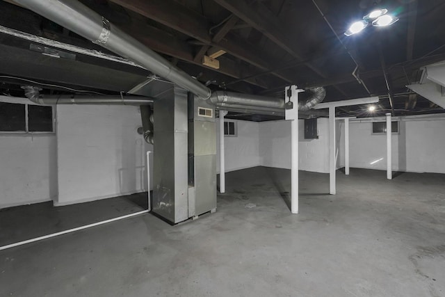 basement featuring electric panel and heating unit