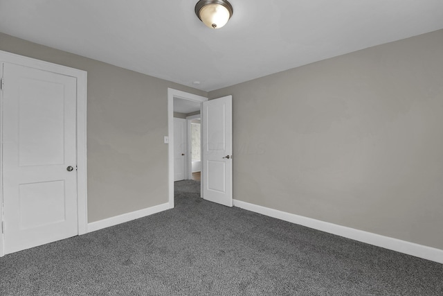 unfurnished bedroom featuring dark colored carpet and a closet