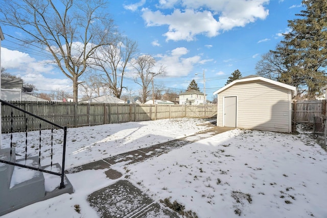 yard covered in snow with a storage shed