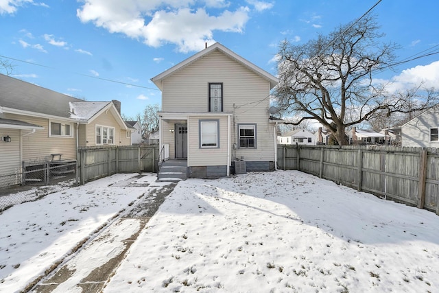 snow covered rear of property with central air condition unit