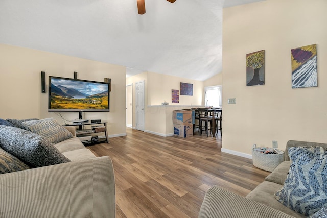 living room featuring lofted ceiling, hardwood / wood-style flooring, and ceiling fan