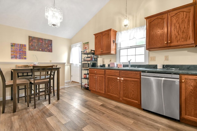 kitchen featuring dishwasher, lofted ceiling, sink, hanging light fixtures, and light hardwood / wood-style flooring