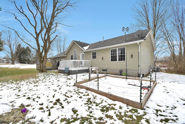 snow covered house with a wooden deck