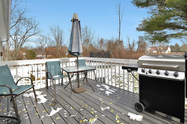 snow covered deck featuring area for grilling and a trampoline