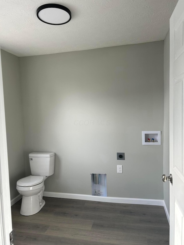 bathroom featuring toilet, wood-type flooring, and a textured ceiling