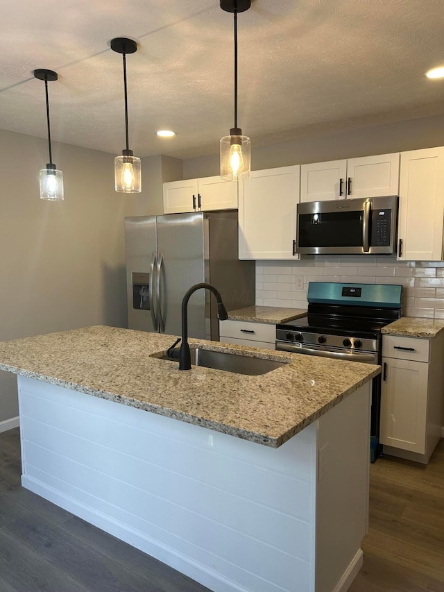 kitchen with decorative light fixtures, sink, white cabinets, and appliances with stainless steel finishes