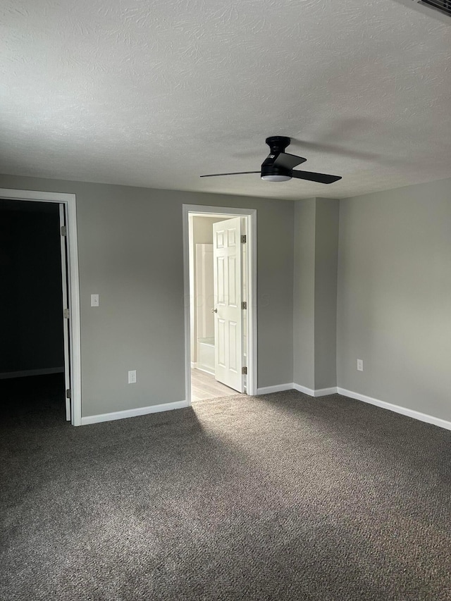 carpeted spare room featuring a textured ceiling and ceiling fan