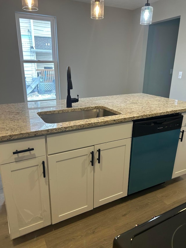 kitchen featuring decorative light fixtures, sink, dishwasher, and light stone countertops