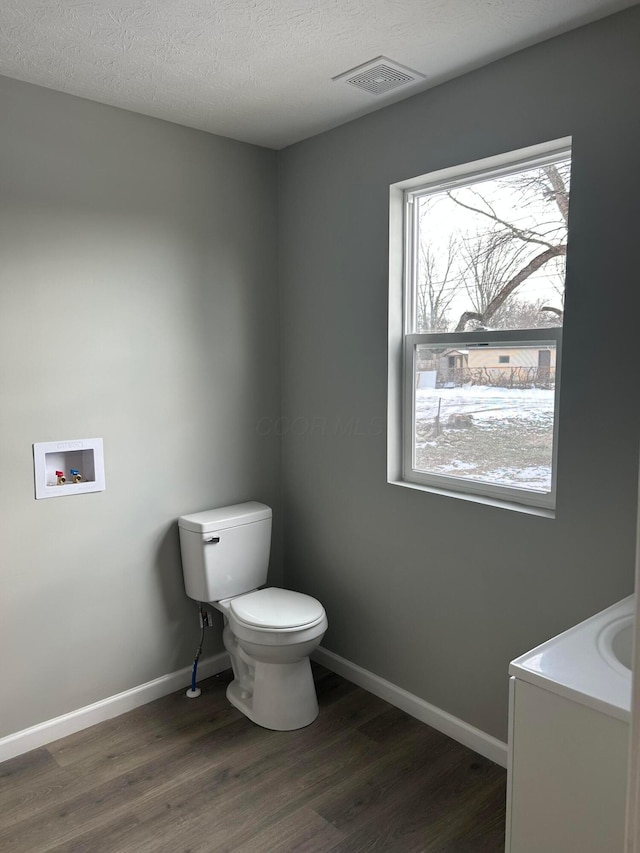 bathroom featuring toilet, a textured ceiling, hardwood / wood-style floors, and vanity