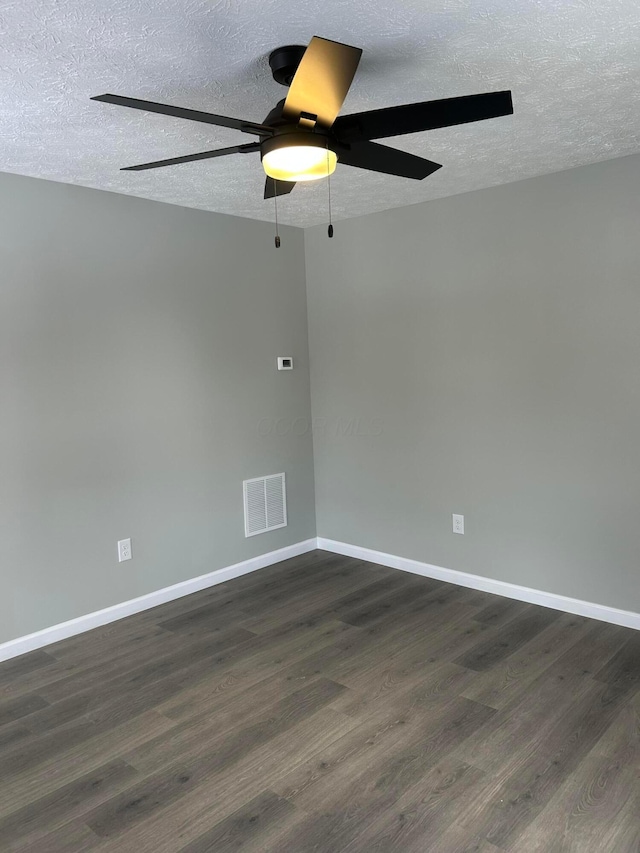 unfurnished room with a textured ceiling, dark wood-type flooring, and ceiling fan