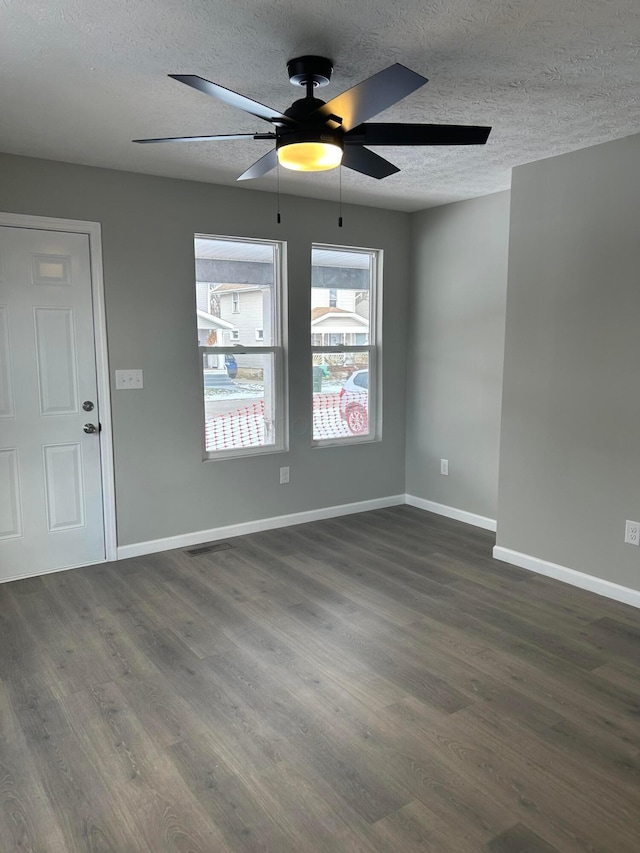 unfurnished room featuring a textured ceiling, ceiling fan, and dark hardwood / wood-style floors