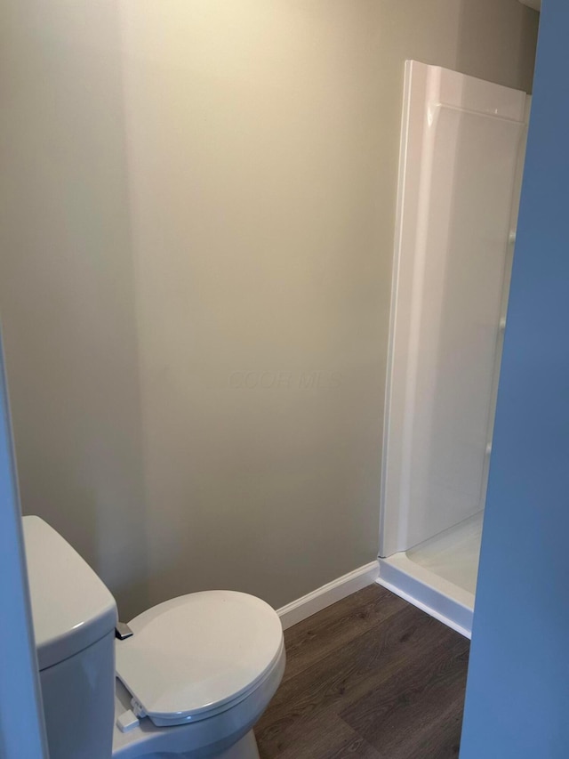 bathroom with toilet, hardwood / wood-style flooring, and walk in shower