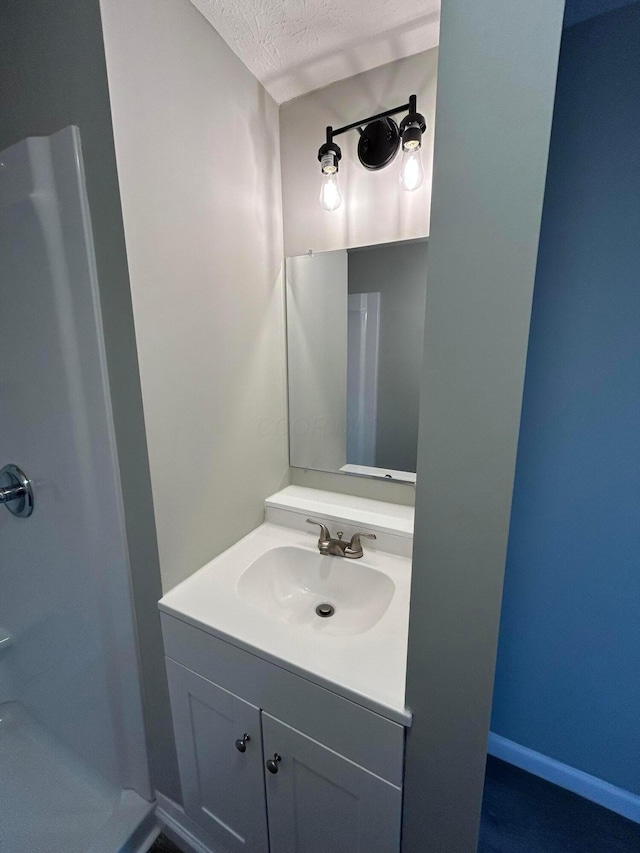 bathroom featuring a textured ceiling and vanity