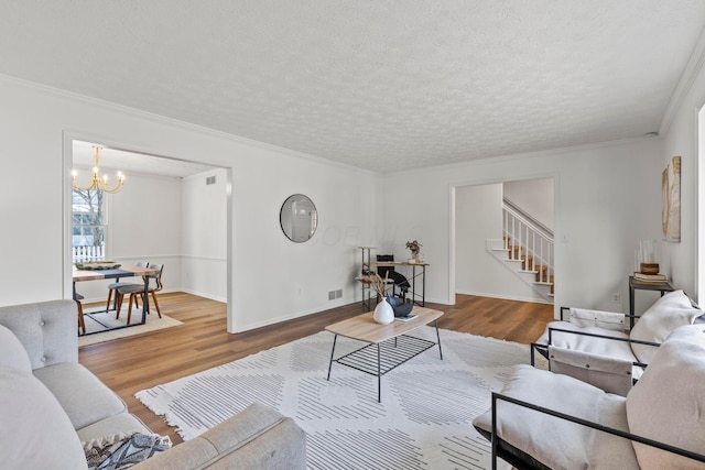 living room with hardwood / wood-style floors, crown molding, and a textured ceiling