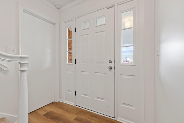 entrance foyer featuring ornamental molding and light hardwood / wood-style floors