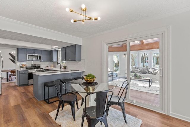 dining area featuring an inviting chandelier, ornamental molding, dark hardwood / wood-style floors, and sink