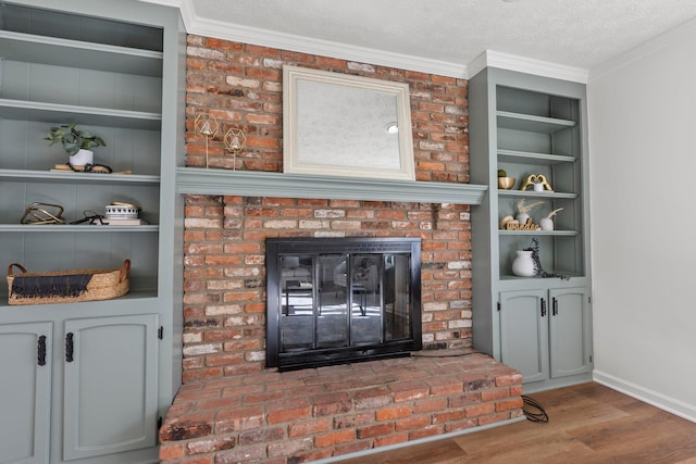 interior details with a fireplace, wood-type flooring, crown molding, a textured ceiling, and built in shelves