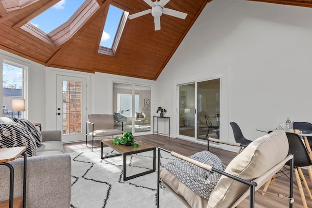 sunroom with ceiling fan, vaulted ceiling with skylight, and wooden ceiling