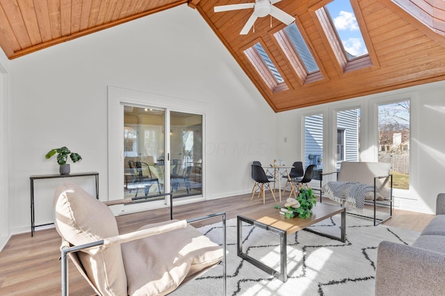 living room with high vaulted ceiling, wooden ceiling, light hardwood / wood-style floors, and a skylight