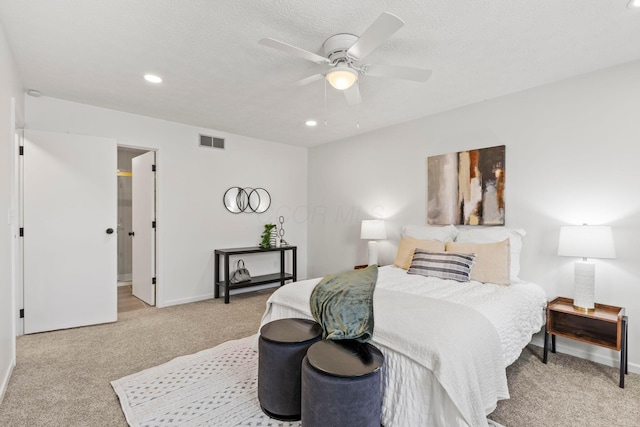 bedroom with connected bathroom, ceiling fan, light colored carpet, and a textured ceiling